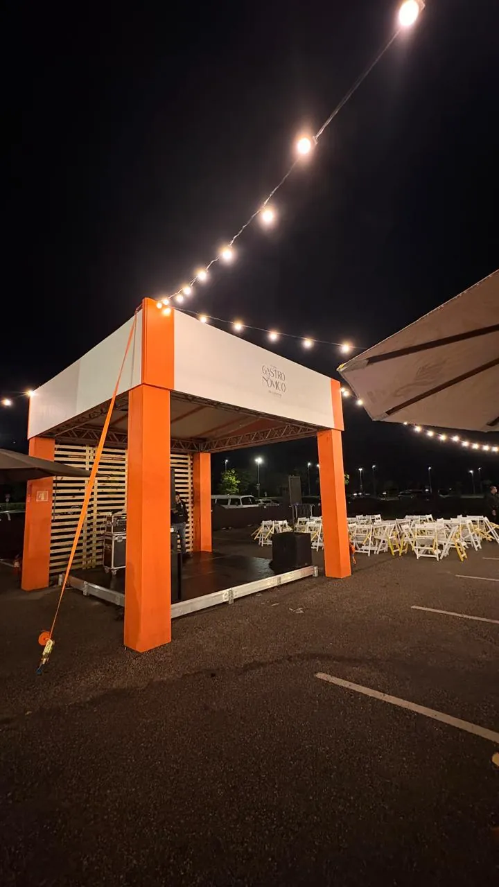 Estrutura laranja iluminada com cordão de luzes