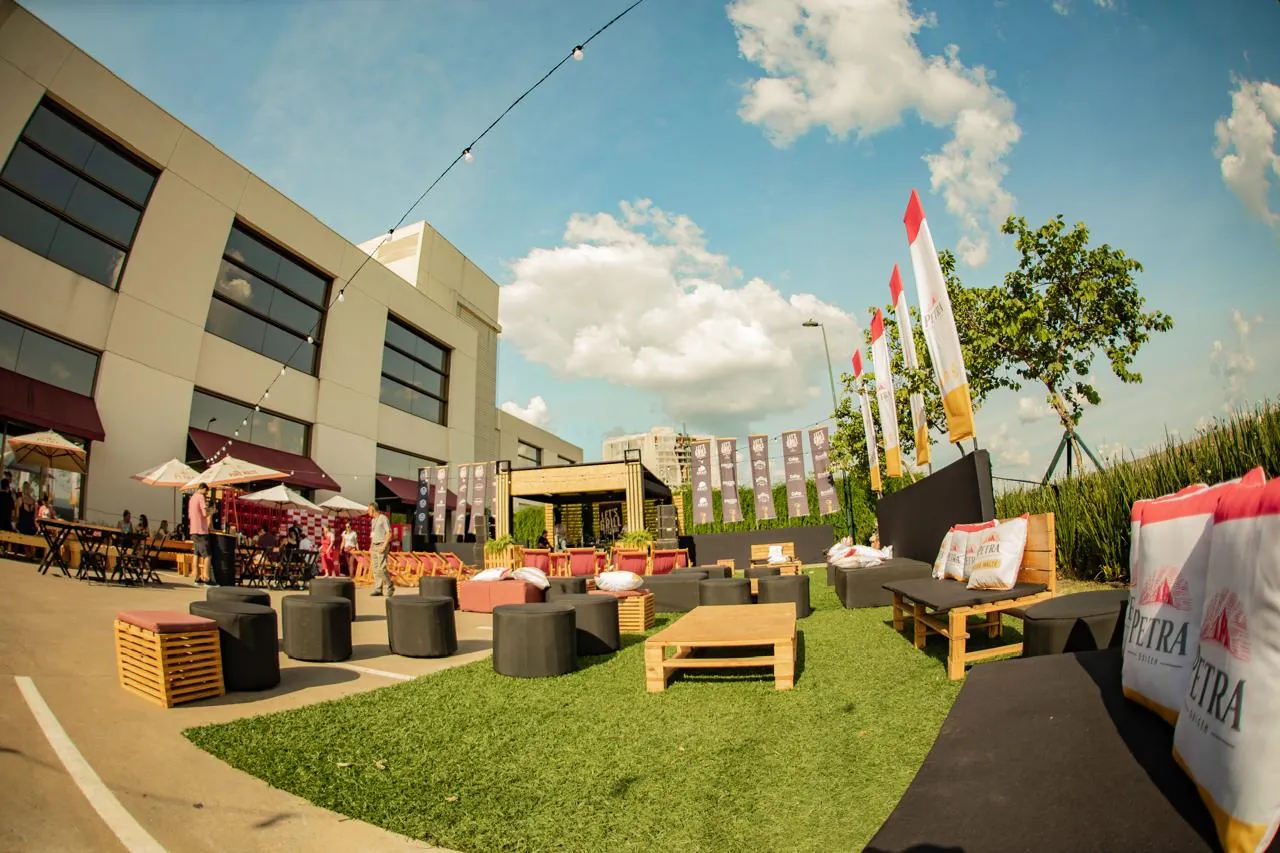 Área de lounge com gramado e sofás em shopping