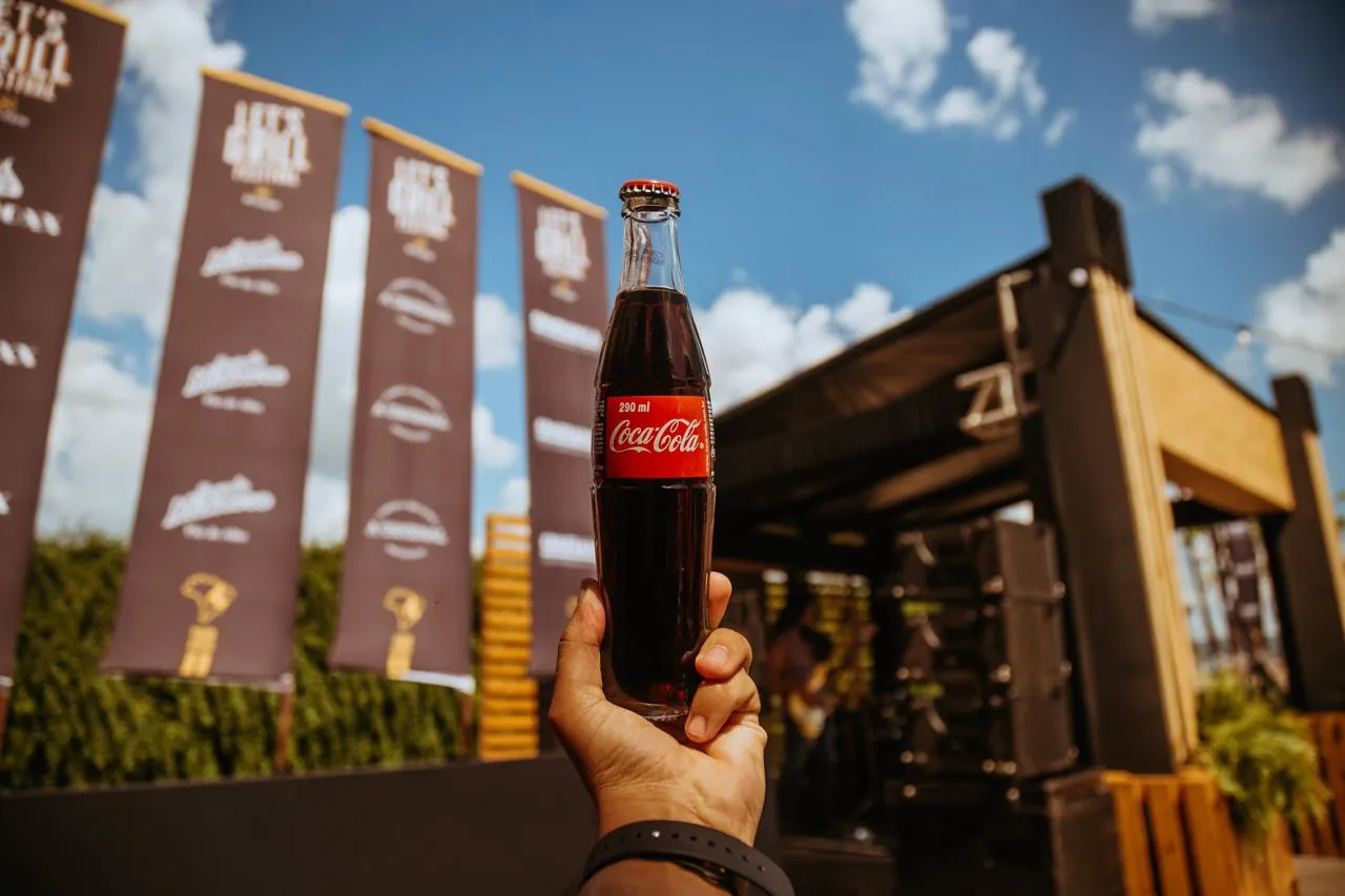 Bandeirolas e garrafa de Coca-Cola em ambientação
