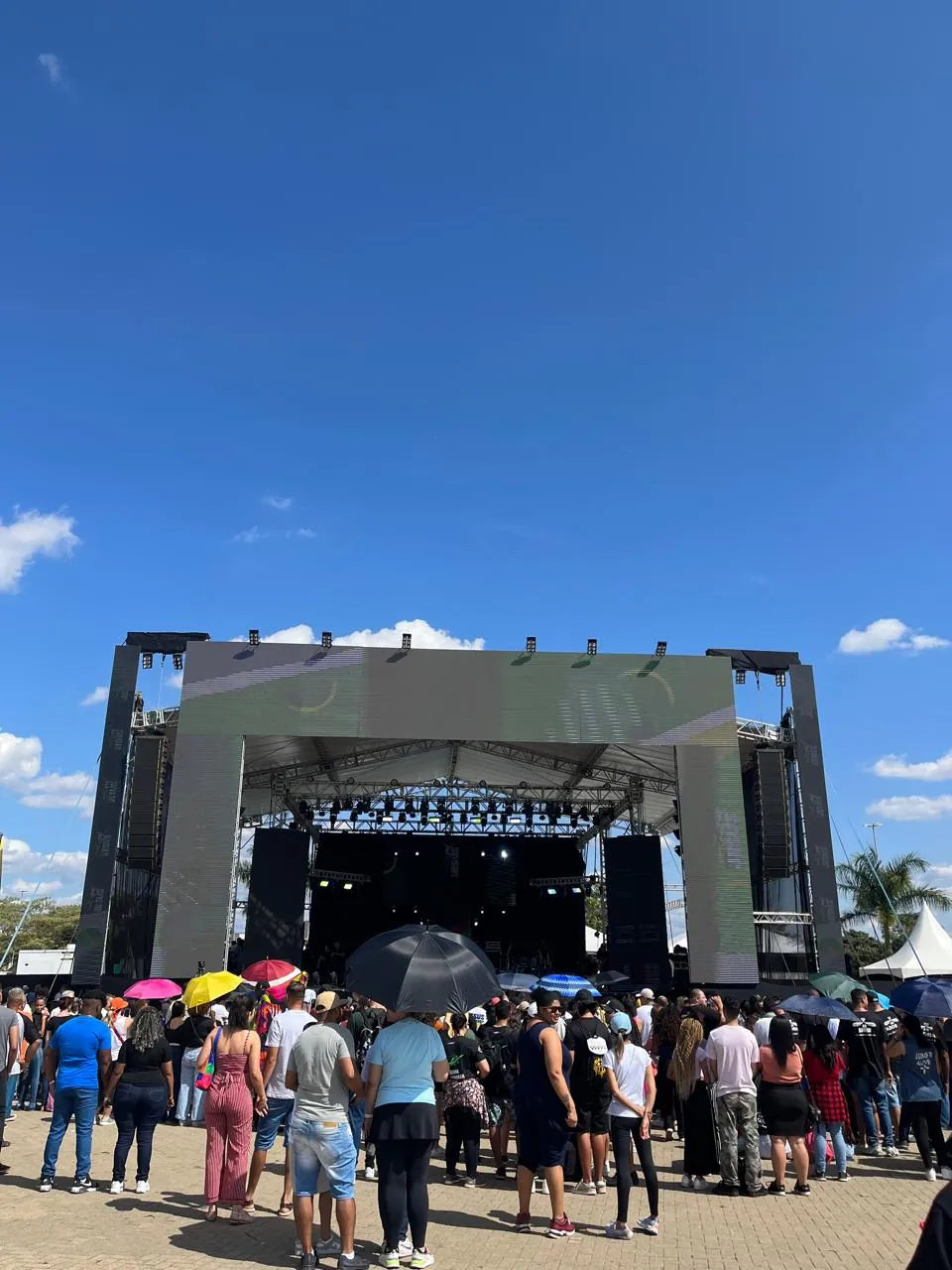 Palco com público sob guarda-chuvas coloridos