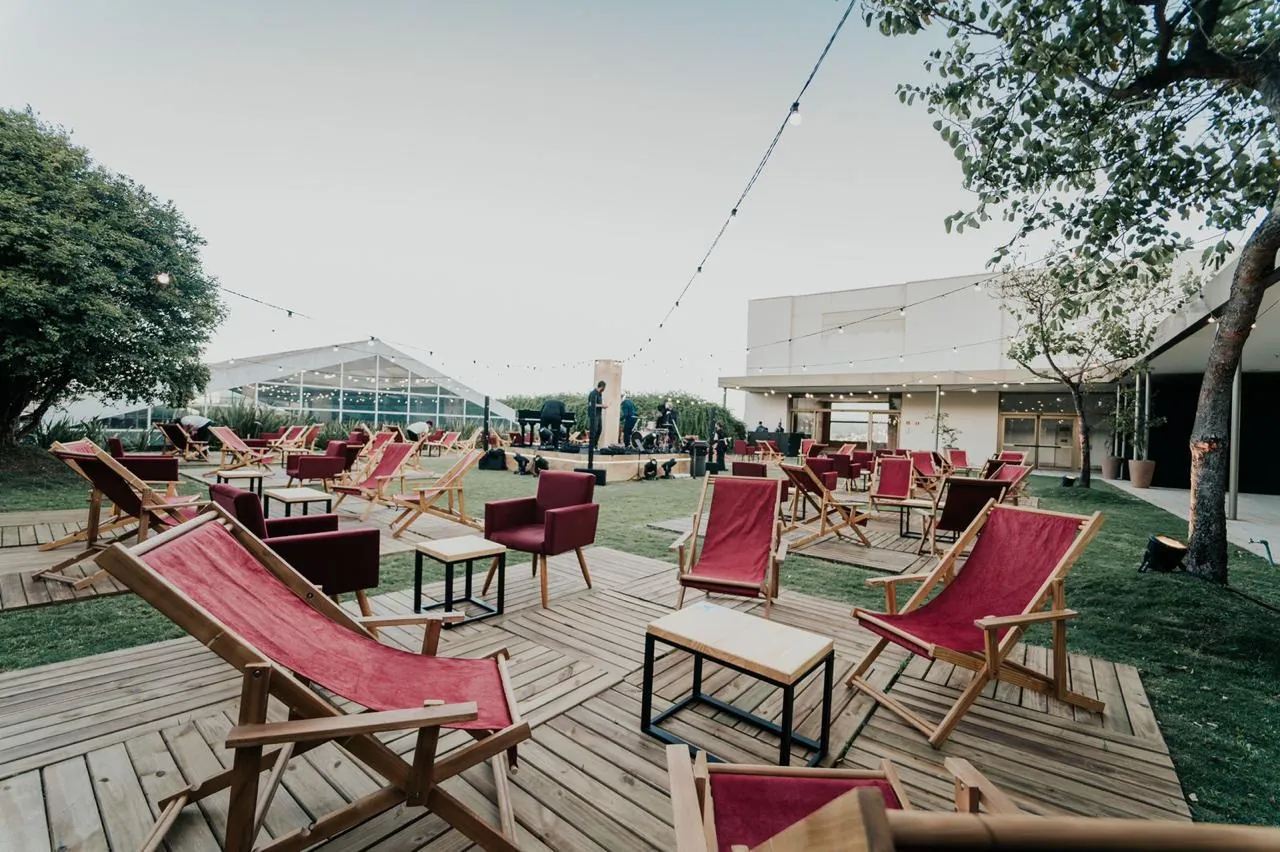 Lounge ao ar livre com espreguiçadeiras e poltronas vermelhas