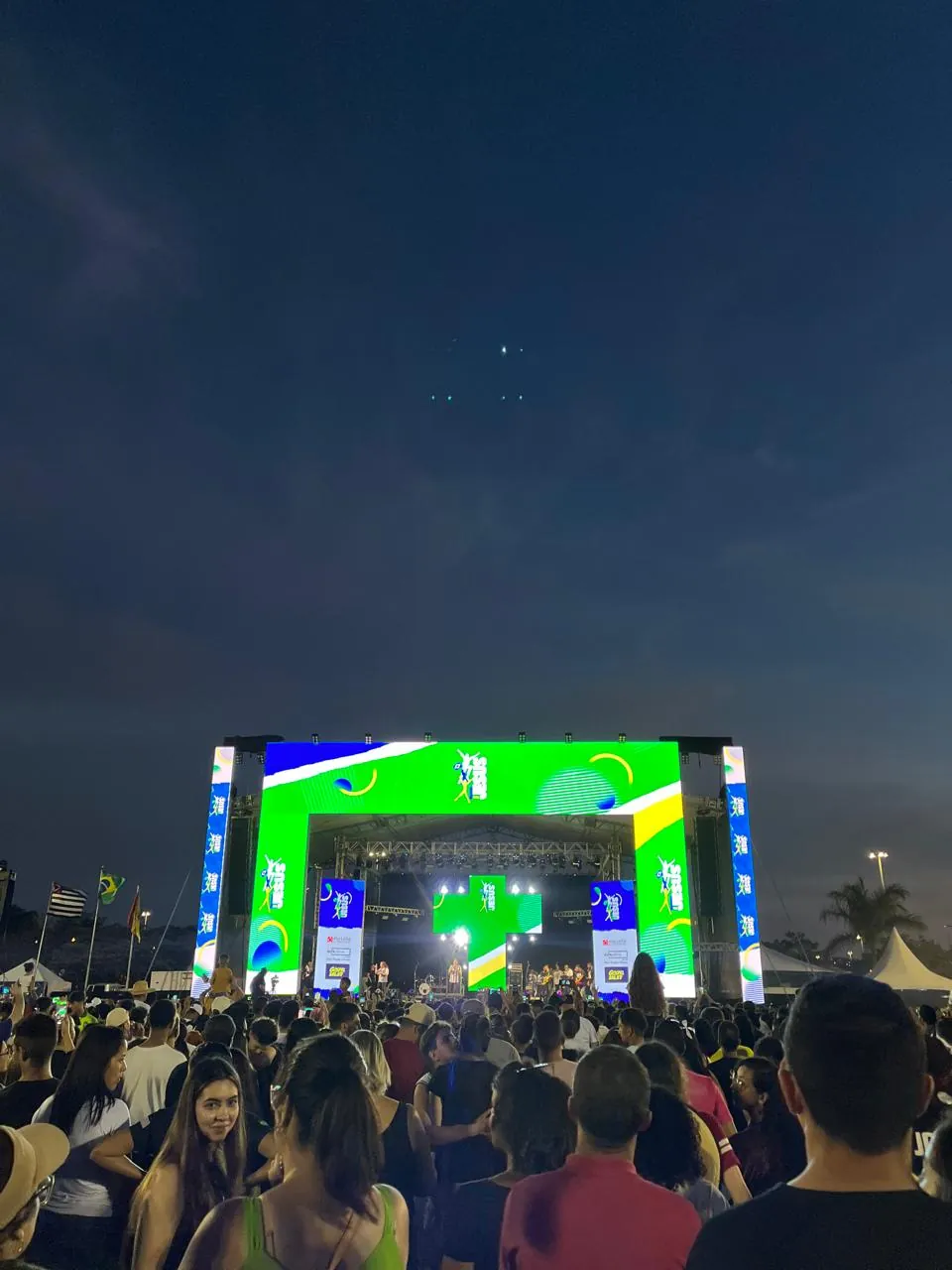 Palco com painel de LED verde e amarelo à noite