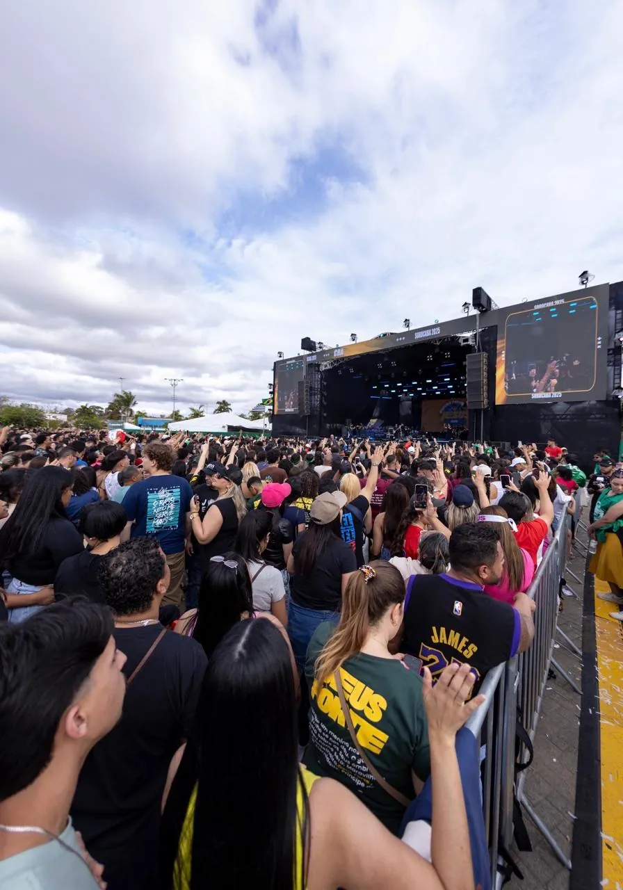 Público em grade de contenção diante do palco